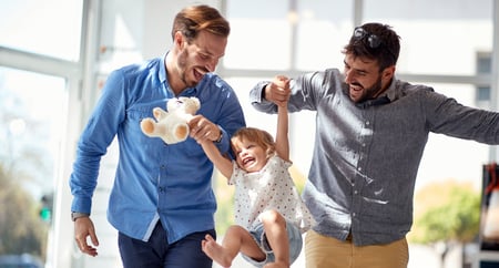 gay male couple lifting up child